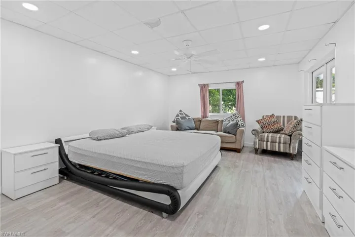 Bedroom featuring a drop ceiling, recessed lighting, and light wood-style floors