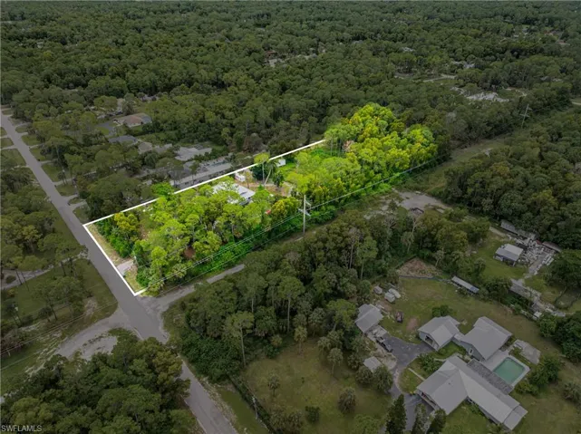 Aerial perspective of suburban area with property boundaries highlighted and a forest
