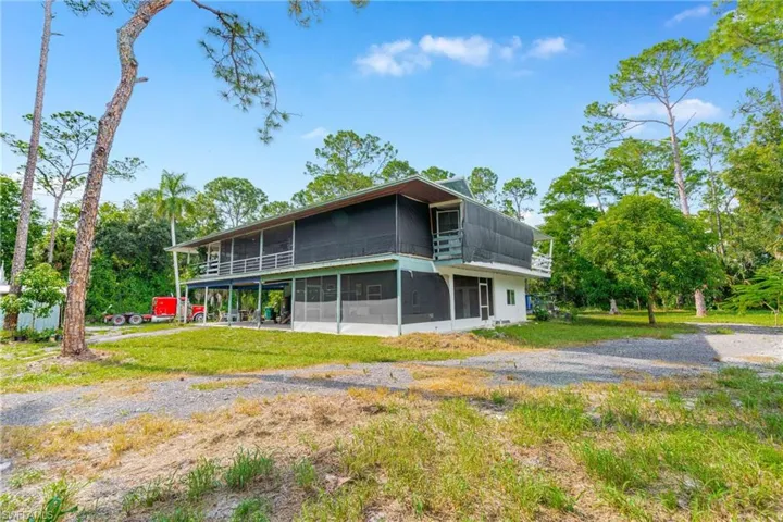 Back of property featuring a sunroom and a lawn