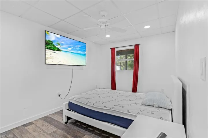 Bedroom featuring wood finished floors, ceiling fan, recessed lighting, and a drop ceiling