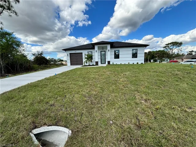 View of front of property with a garage and a front yard