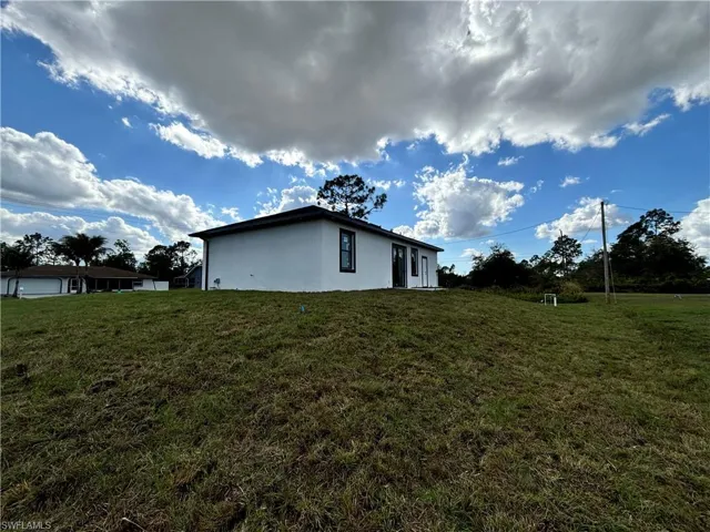 View of side of home featuring a lawn