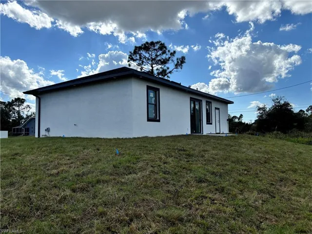 View of side of property featuring a lawn