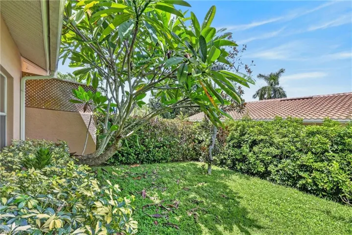 Lush outdoor area featuring mature trees, landscaped shrubbery, and a well-maintained lawn