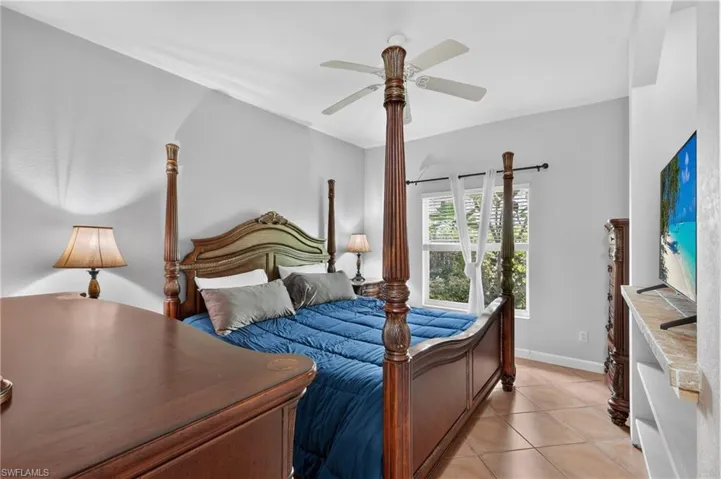 Vaulted ceiling, ceiling fan, tiled flooring, window with blinds, recessed shelving