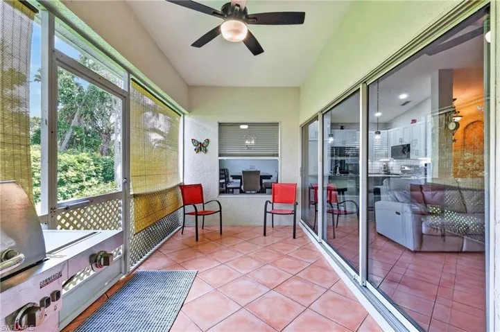 Screened patio with diagonal tile flooring, a ceiling fan, and sliding glass door access to interior spaces