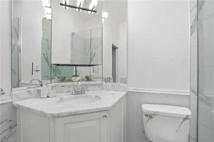 Guest bath with single vanity and custom marble finishes