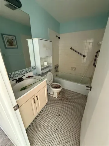 Full bathroom featuring toilet, vanity, tile patterned floors, and tiled shower / bath combo