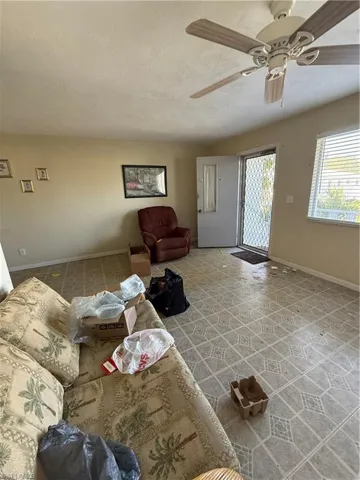 Living room with a textured ceiling and ceiling fan