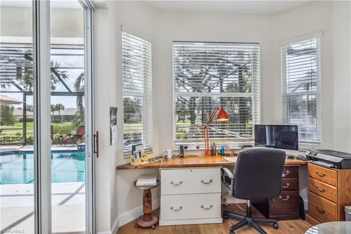 built in desk with pool and golf views near kitchen table