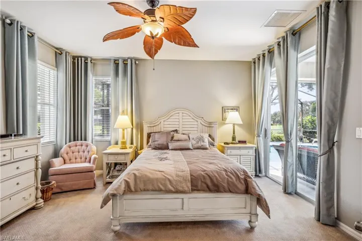 Carpeted bedroom with access to outside, ceiling fan, and multiple windows