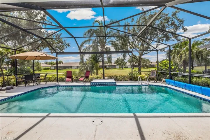 View of swimming pool with a patio area and screen, picture window to golf course, enclosure