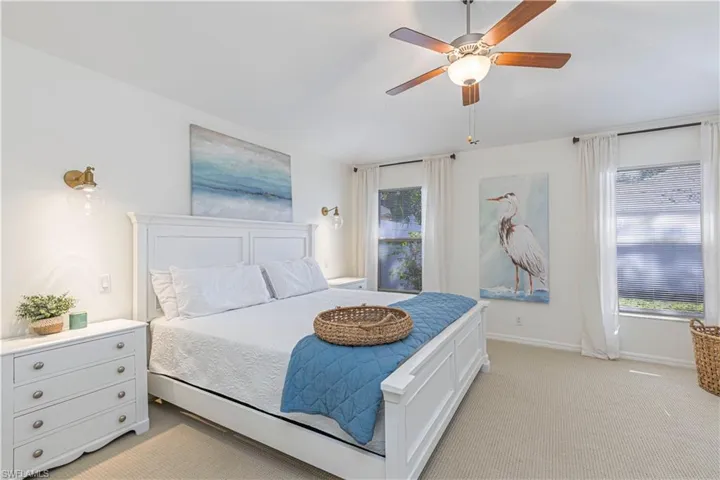 Bedroom featuring light carpet and ceiling fan access to lanai