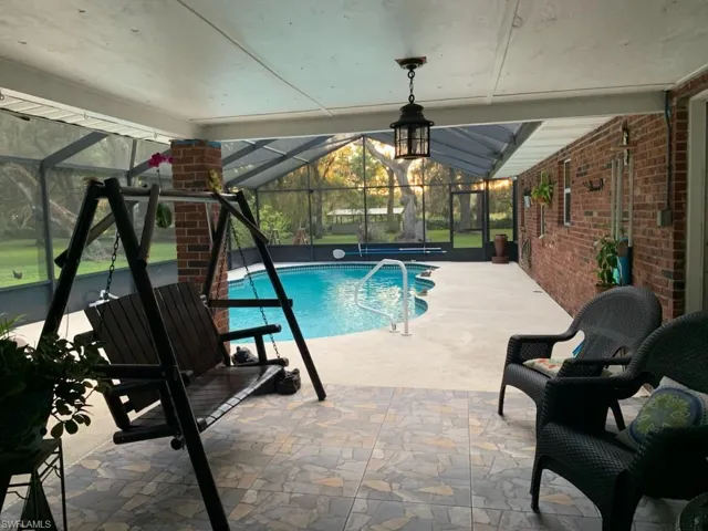 Swimming pool with a sunroom, a patio, and a lanai