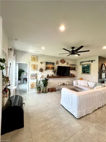 Living room featuring a ceiling fan, light tile  floors, and recessed lighting