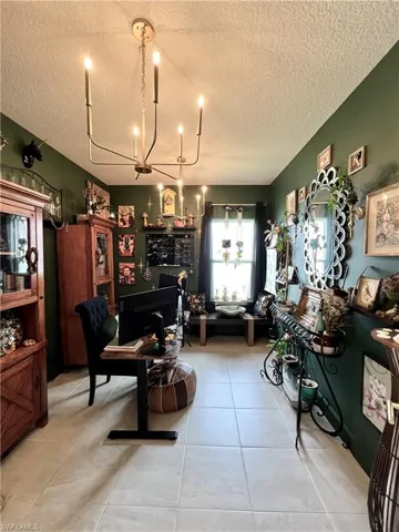 Beautiful Den/Home Office with French doors and 2 elegant chandeliers.