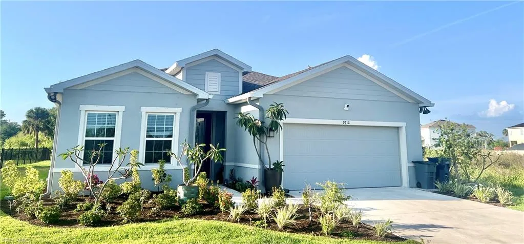 View of front of home featuring a 2 car garage, concrete driveway, stucco siding, and fence on only neighbor side. Please note the house is surrounded by preserves.
