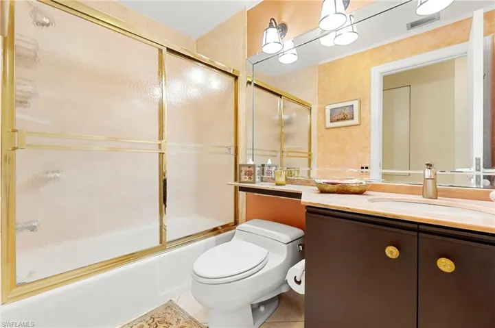 Full bathroom with vanity, enclosed tub / shower combo, and light tile patterned floors