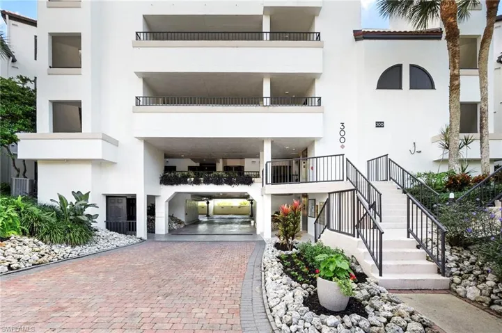 View of apartment building / complex featuring a carport and decorative driveway