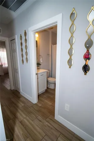 Corridor featuring wood tiled floors and baseboards