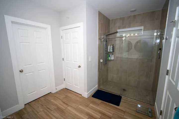 Full bath with a stall shower and wood finished floors