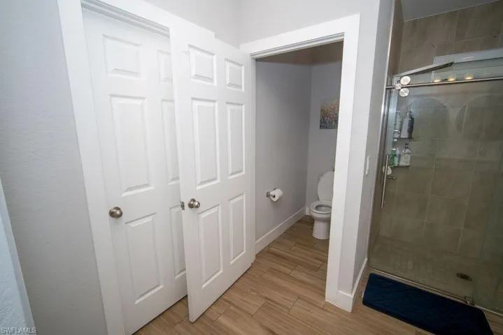 Bathroom with light wood-style flooring and a stall shower