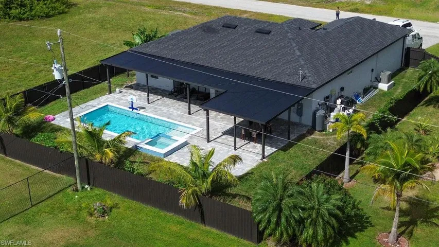 View of pool with a patio, a fenced backyard, and a pool with connected hot tub