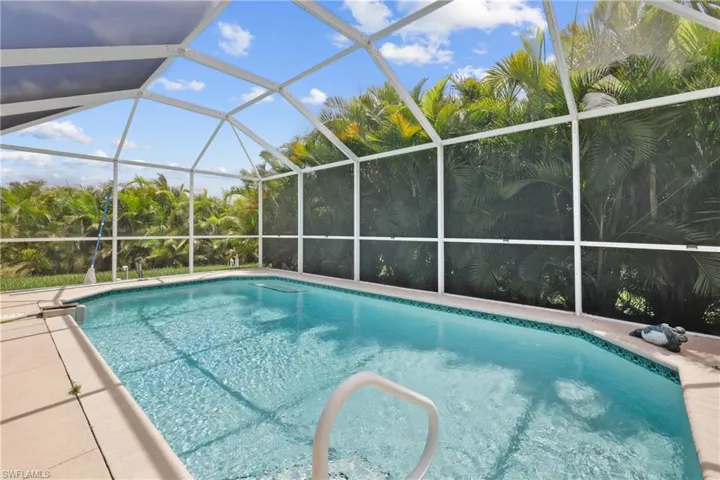 View of swimming pool featuring glass enclosure