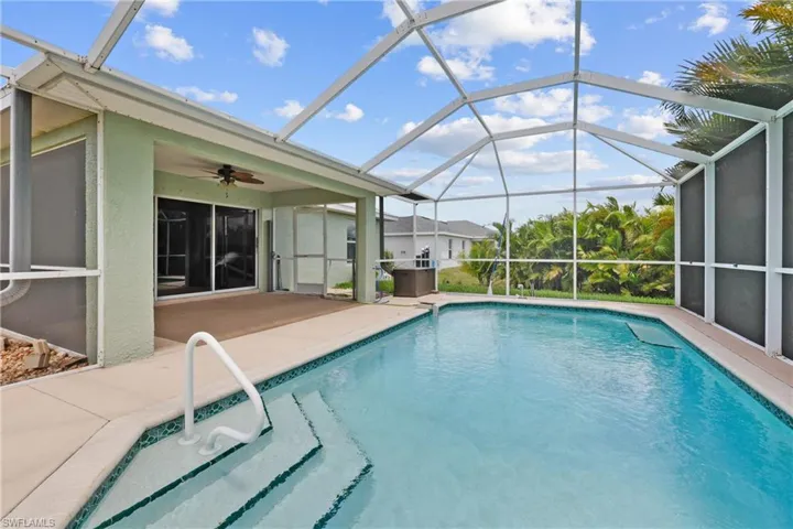 View of swimming pool with a lanai, a patio area, and ceiling fan