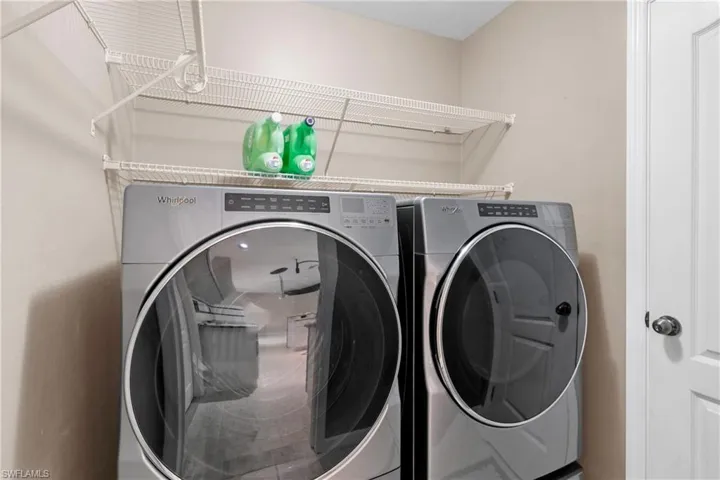 Clothes washing area featuring washer and dryer and extra linen closet
