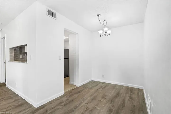 Unfurnished dining area with a chandelier, a textured ceiling