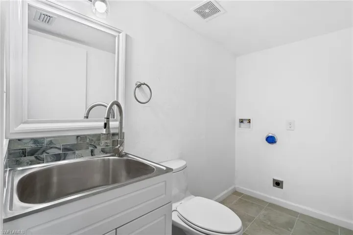 Bathroom with tile patterned floors, vanity, and toilet. Washer Dryer Hook up. First Floor Bathroom