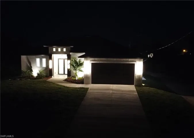 View of front of property featuring driveway, an attached garage, and stucco siding