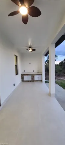 Patio terrace at dusk featuring sink and area for grilling