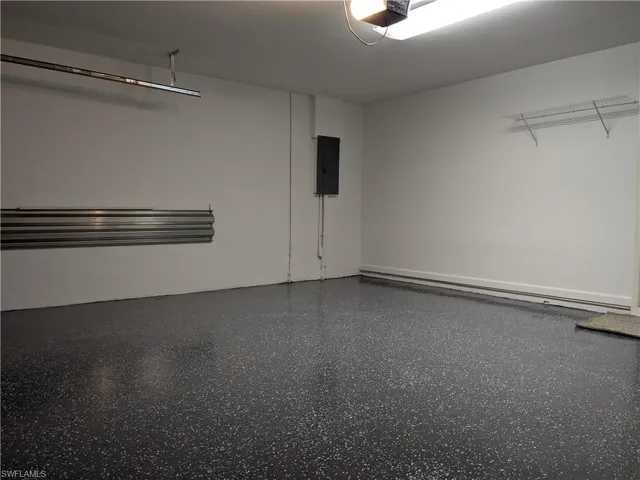 Garage featuring a garage door opener and electric panel