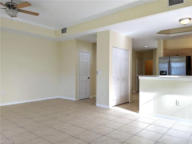Empty room featuring ornamental molding and light tile patterned floors