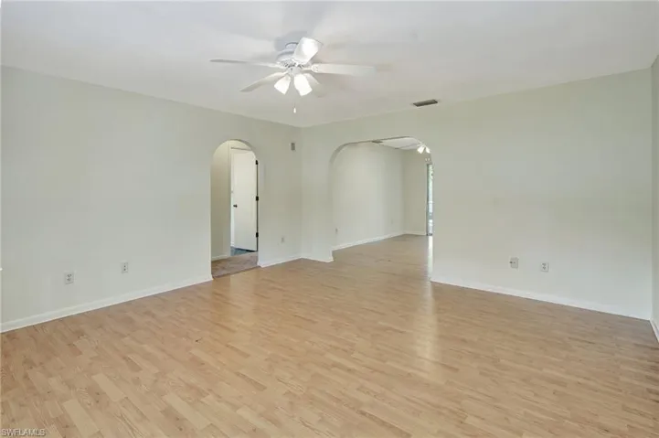 Empty room with ceiling fan and light hardwood / wood-style floors
