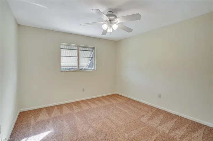 Carpeted empty room featuring ceiling fan