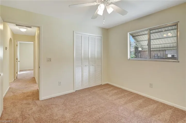 Unfurnished bedroom featuring a closet, ceiling fan, and light colored carpet