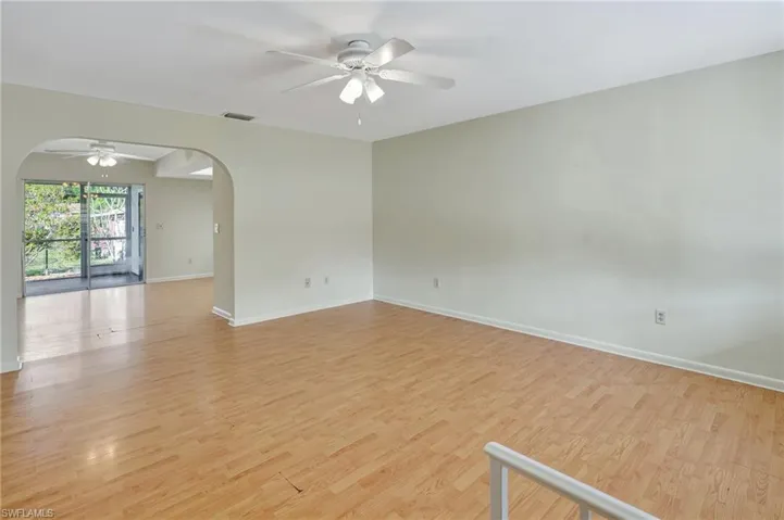 Empty room with ceiling fan and light wood-type flooring