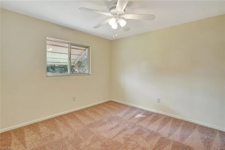 Spare room with ceiling fan and carpet