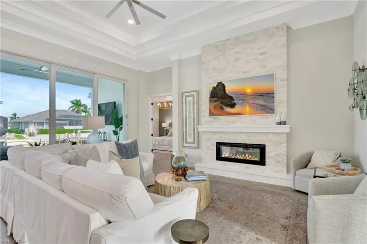 Stacked stone accent wall featuring a modern electric fireplace with a white mantel