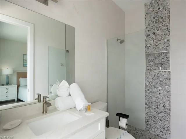 Modern bathroom featuring a floating vanity with rectangular vessel sink, polished nickel fixtures, and quartz countertop