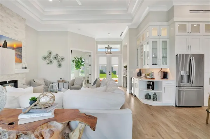Open-concept living space featuring wood-finish flooring and a coffered ceiling