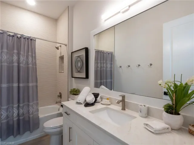 Spa-inspired bathroom featuring a floating vanity with quartz countertop, vessel sink, and polished chrome fixtures