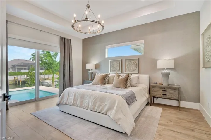 Room featuring wide plank wood-finish flooring, a textured accent wall, and a circular chandelier