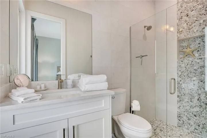Bathroom featuring a white vanity with a rectangular undermount sink, a quartz countertop, and a brushed nickel faucet