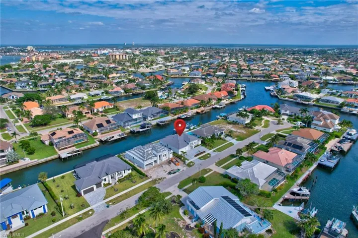 Waterfront property featuring a private boat dock, direct canal access, and a manicured lawn