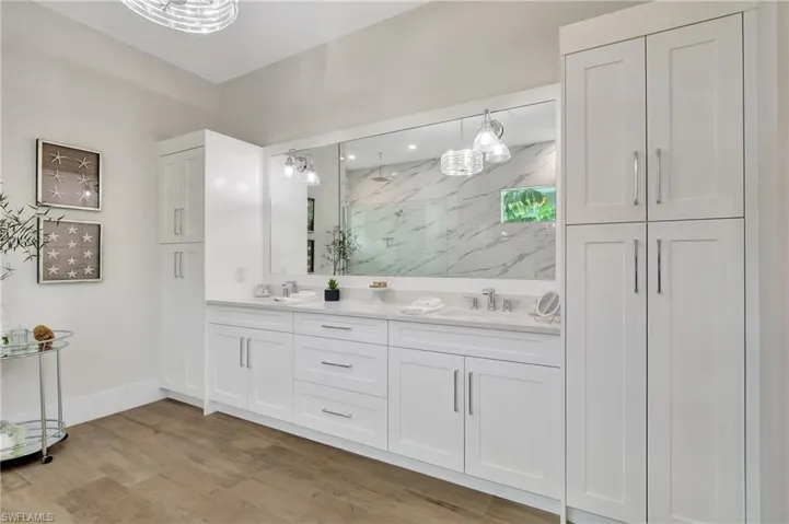Double vanity with quartz countertop, dual sinks, and chrome fixtures