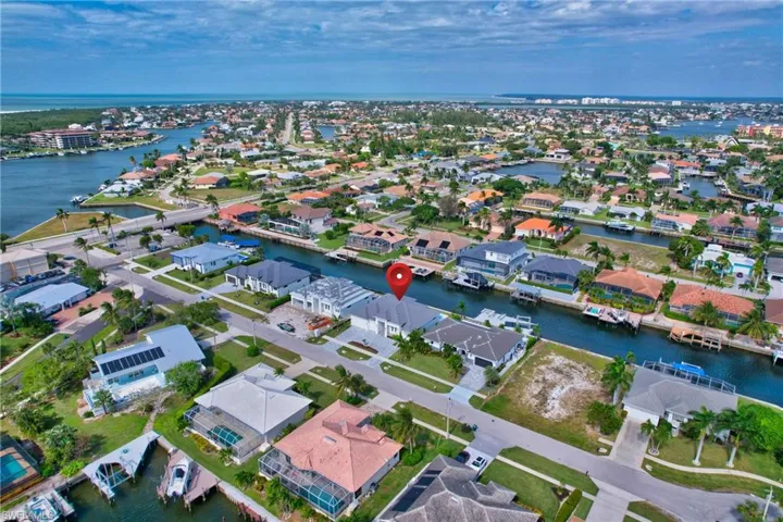Waterfront property with direct canal access, featuring a private boat dock, a two-car garage, and a concrete driveway